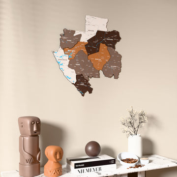 Soil Gabon wooden wall map on a beige wall above a console with figurines