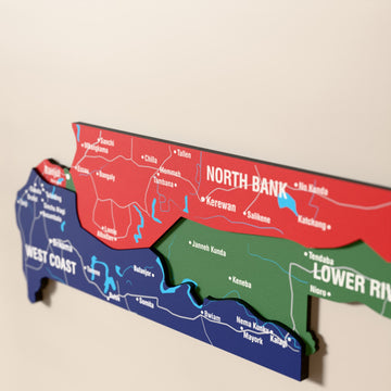 Close-up of the Flag colored Gambia wooden wall map with layered regions and printed names