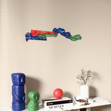 Flag colored Gambia wooden wall map on a beige wall above a console with figurines