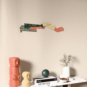 Sage Gambia wooden wall map on a beige wall above a console with figurines