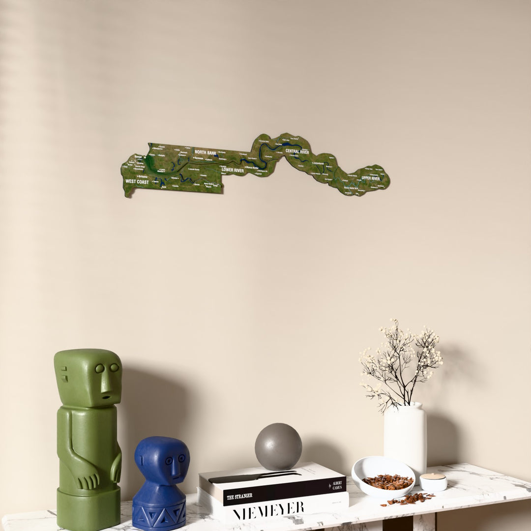 Satellite Gambia wooden wall map on a beige wall above a console with figurines