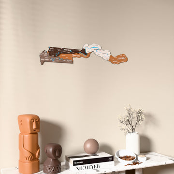 Soil Gambia wooden wall map on a beige wall above a console with figurines