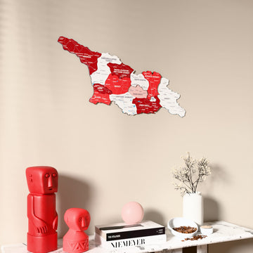 Flag colored Georgia wooden wall map on a beige wall above a console with figurines