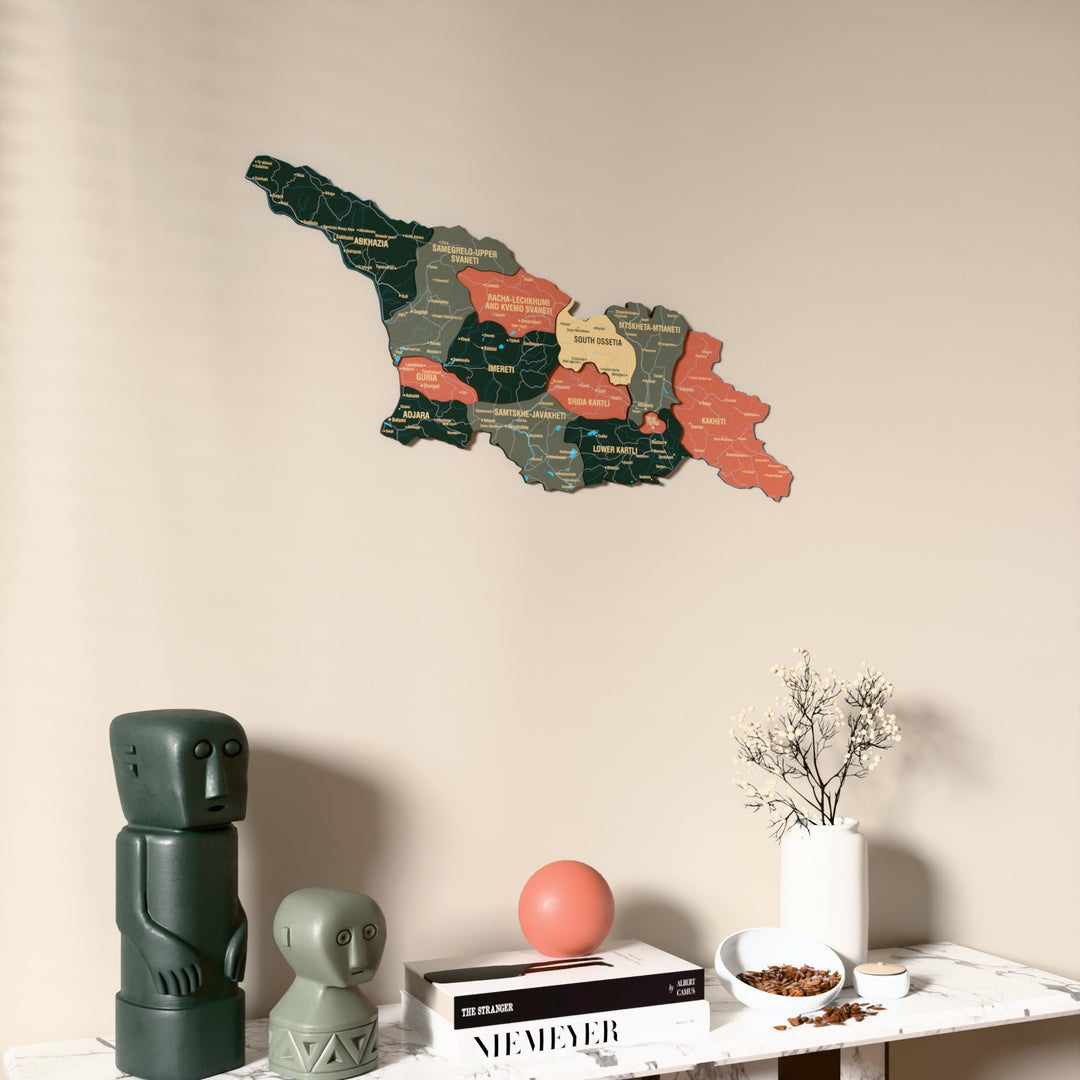 Sage Georgia wooden wall map on a beige wall above a console with figurines