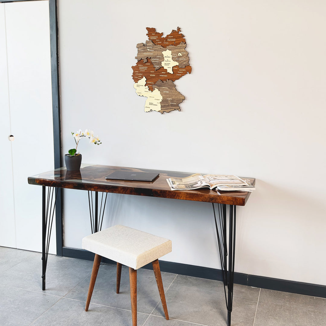 Multicolor layered wood Germany map at upper right of a wide shot with a desk and white stool