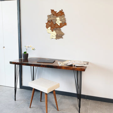 Multicolor layered wood Germany map at upper right of a wide shot with a desk and white stool