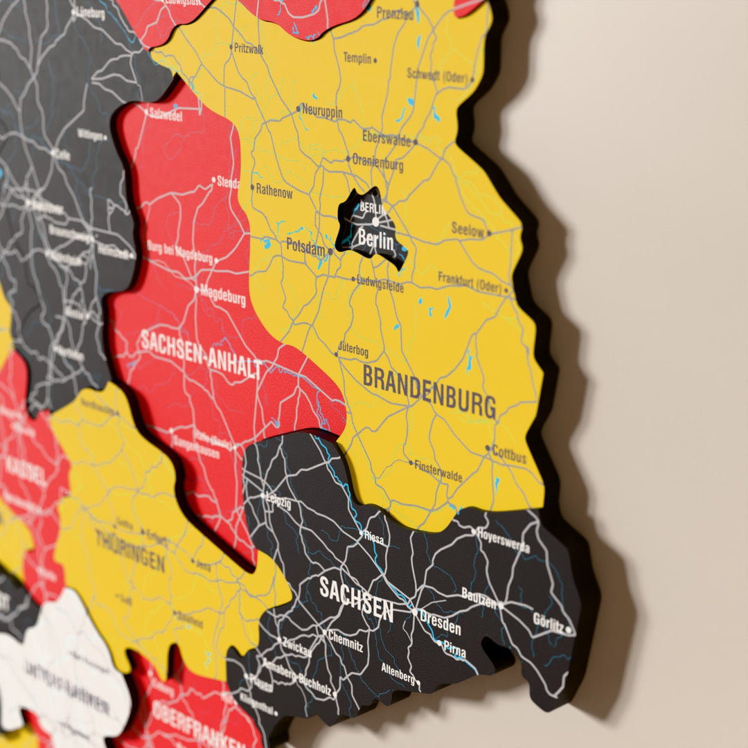 Close-up of the Flag colored Germany wooden wall map with layered regions and printed names