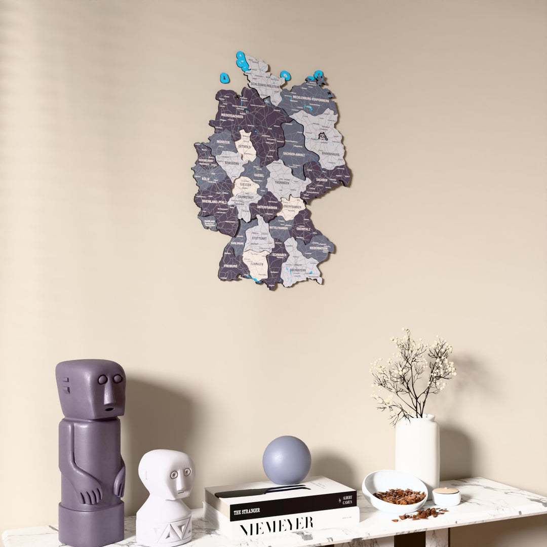 Nimbus Germany wooden wall map on a beige wall above a console with figurines