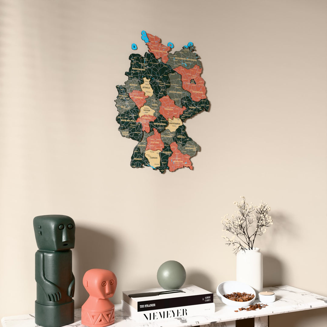 Sage Germany wooden wall map on a beige wall above a console with figurines