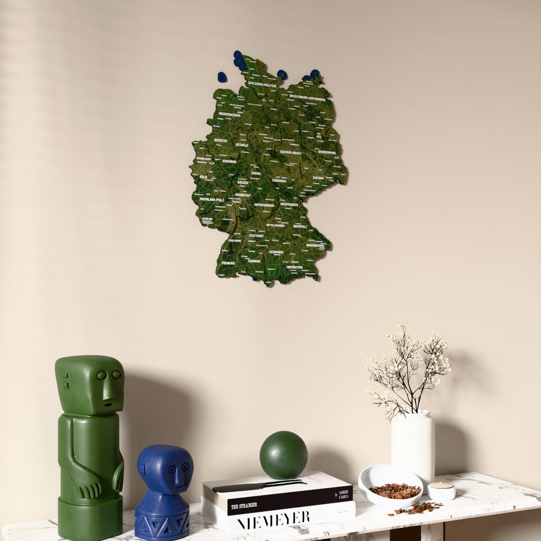 Satellite Germany wooden wall map on a beige wall above a console with figurines