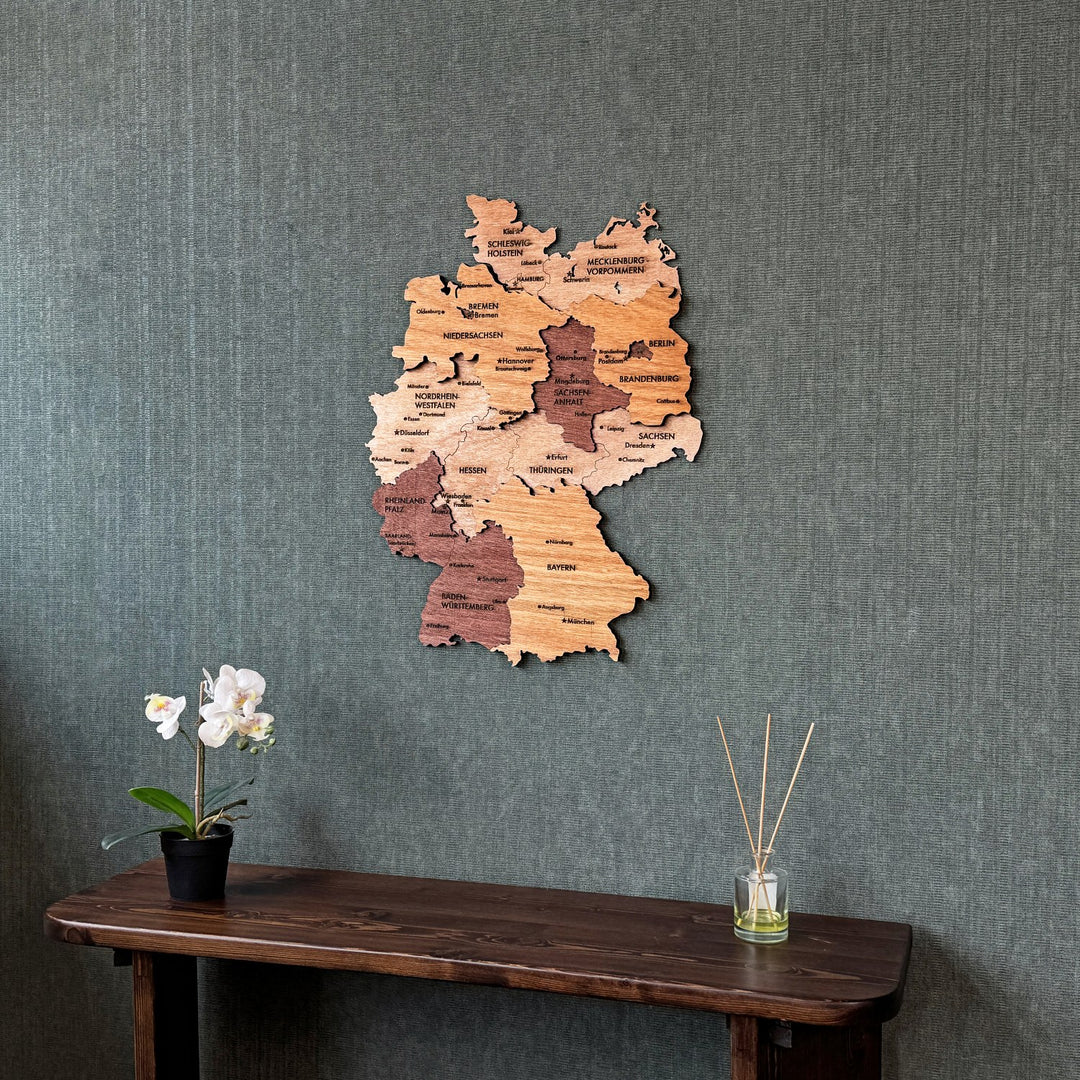 Wooden Germany map centered above a console with a reed diffuser