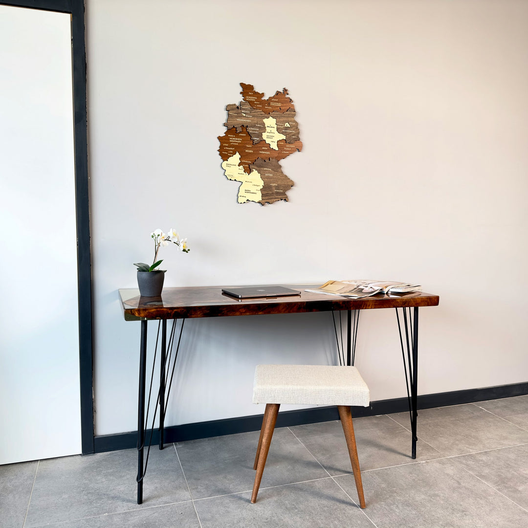 Wide room view with the multicolor wooden Germany map above a hairpin-leg desk and stool