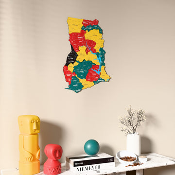 Flag colored Ghana wooden wall map on a beige wall above a console with figurines