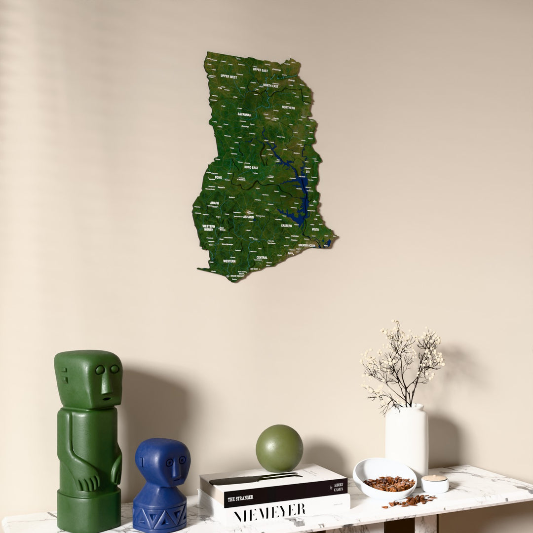 Satellite Ghana wooden wall map on a beige wall above a console with figurines