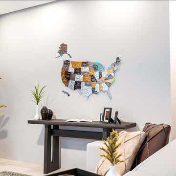 Soil metal United States map on a white wall above a dark console table with a cushion in view