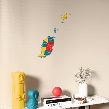 Flag colored Grenada wooden wall map on a beige wall above a console with figurines