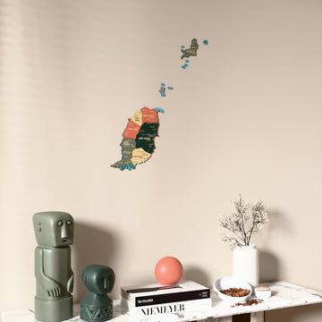 Sage Grenada wooden wall map on a beige wall above a console with figurines
