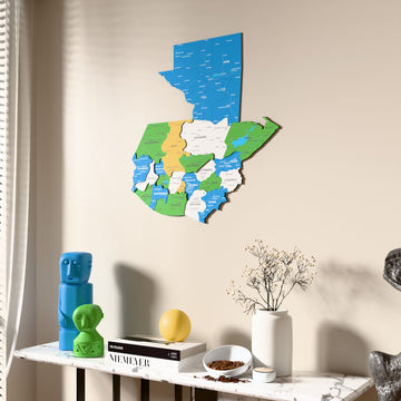 Flag colored Guatemala wooden wall map beside a sheer curtain, angled view