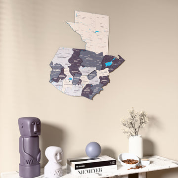 Nimbus Guatemala wooden wall map on a beige wall above a console with figurines