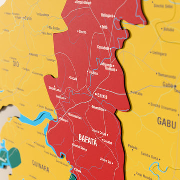 Close-up of the Flag colored Guinea-Bissau wooden wall map with layered regions and printed names