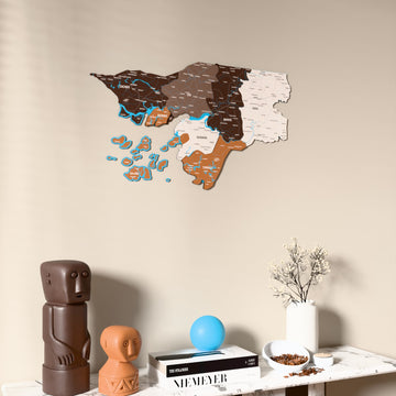 Soil Guinea-Bissau wooden wall map on a beige wall above a console with figurines