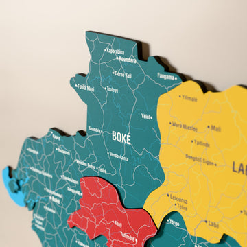 Close-up of the Flag colored Guinea wooden wall map with layered regions and printed names