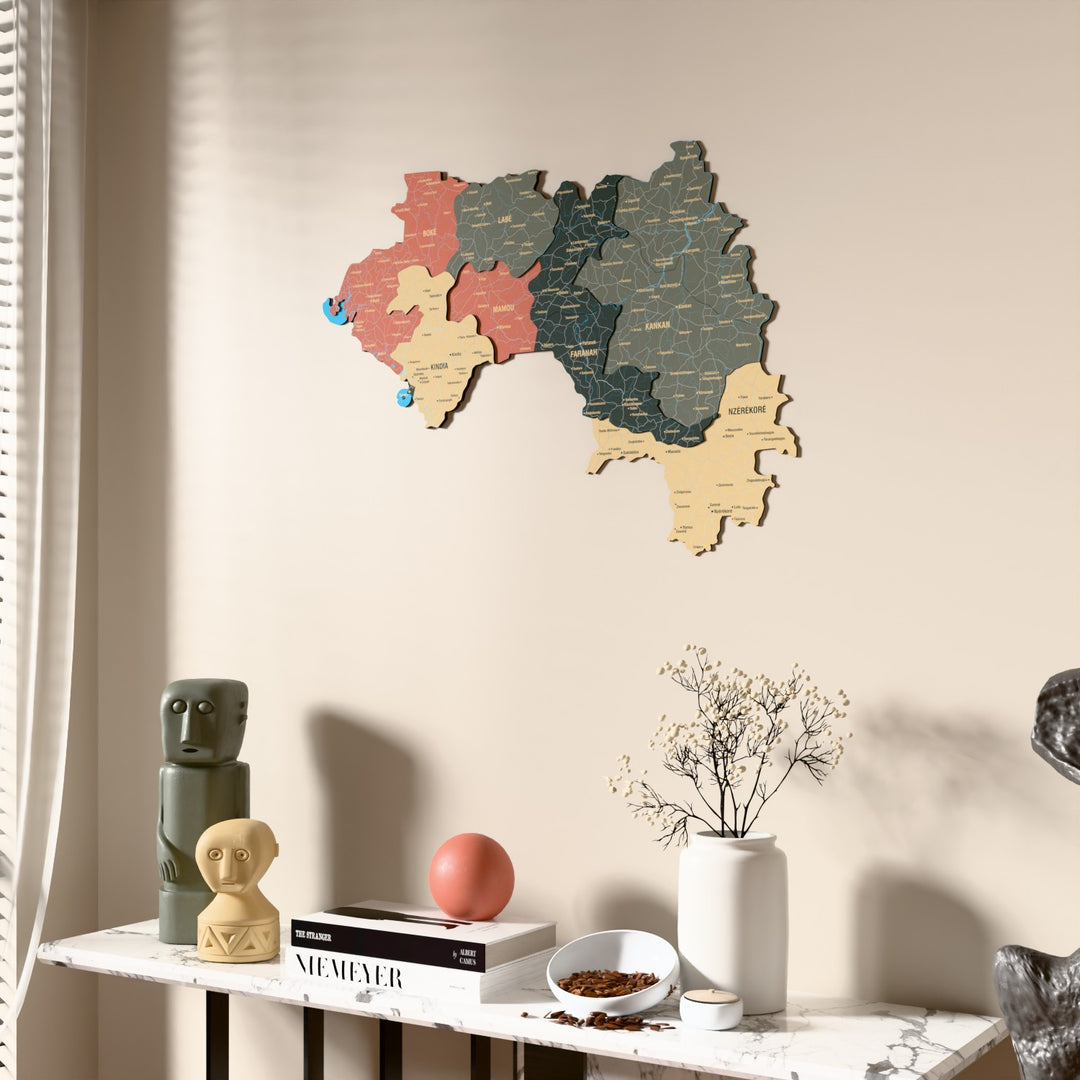 Sage Guinea wooden wall map beside a sheer curtain, angled view