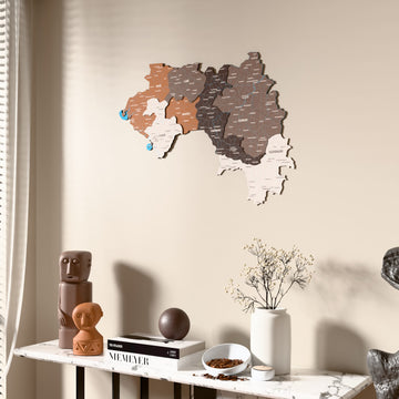 Soil Guinea wooden wall map beside a sheer curtain, angled view