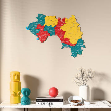 Flag colored Guinea wooden wall map above a marble console, front view