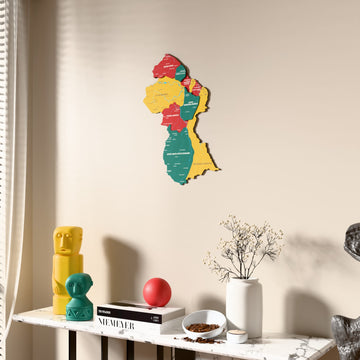 Flag colored Guyana wooden wall map beside a sheer curtain, angled view