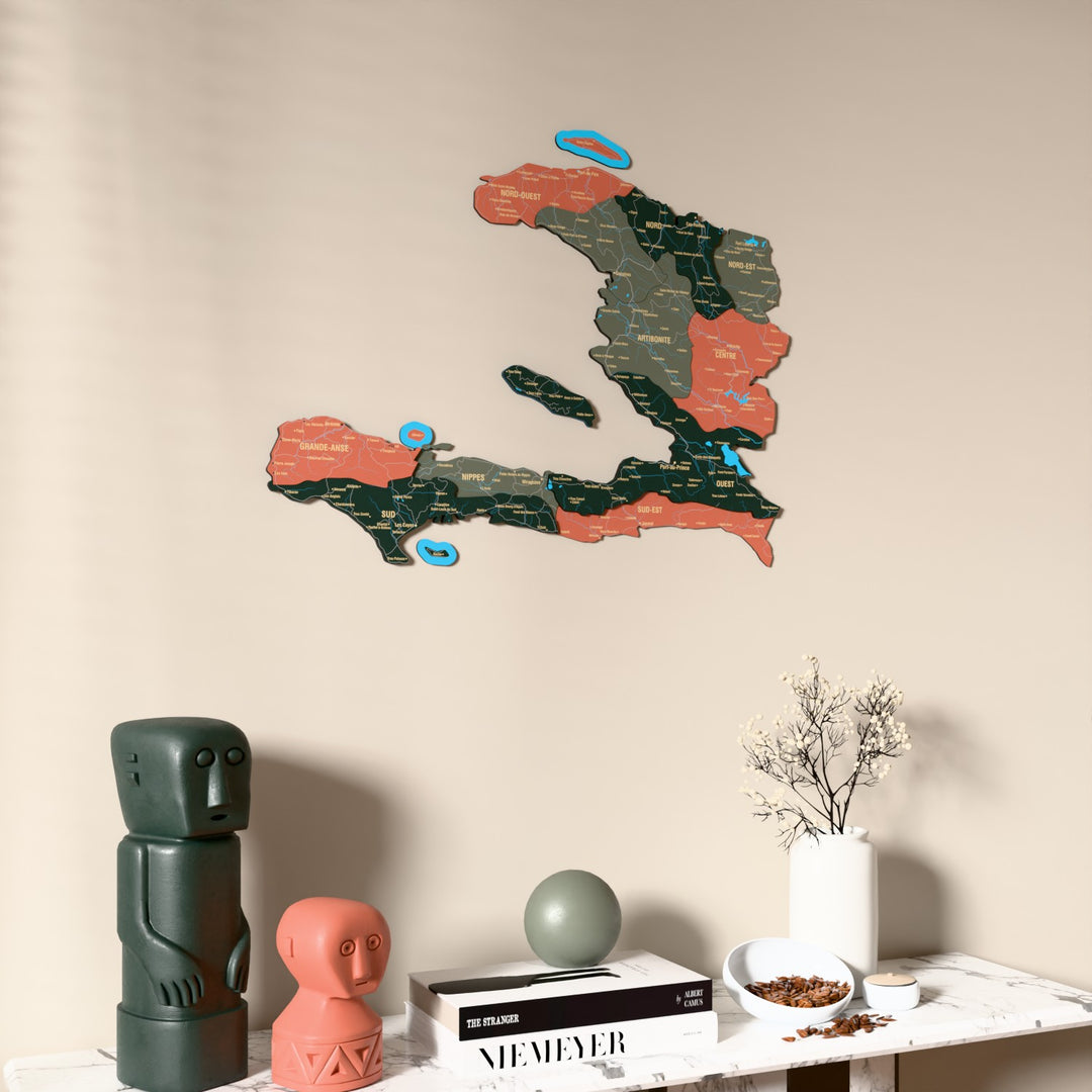 Sage Haiti wooden wall map on a beige wall above a console with figurines
