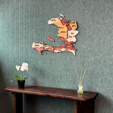 Wooden Haiti map on a green textured wall above a console, slightly angled from the right