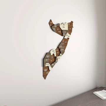 Somalia wooden wall map in a room corner, with the edge of a desk and an open book at the bottom