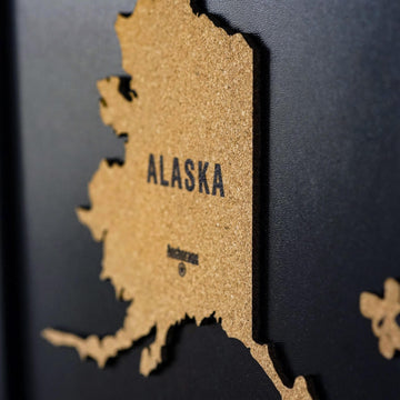Side-angle close-up of the Alaska cork piece on the black USA map board