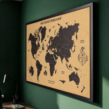 Framed cork world map seen from the left against a green wall, black continents with a custom title and anchor