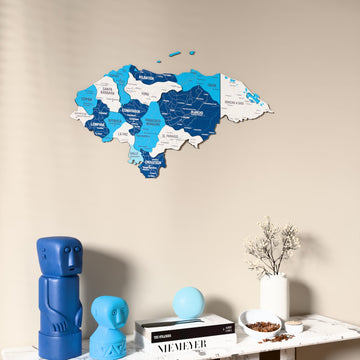 Flag colored Honduras wooden wall map on a beige wall above a console with figurines