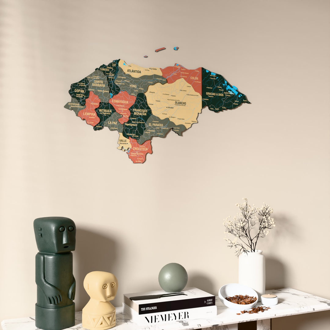 Sage Honduras wooden wall map on a beige wall above a console with figurines