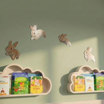 Hopping bunny metal pieces above cloud-shaped bookshelves on a green wall