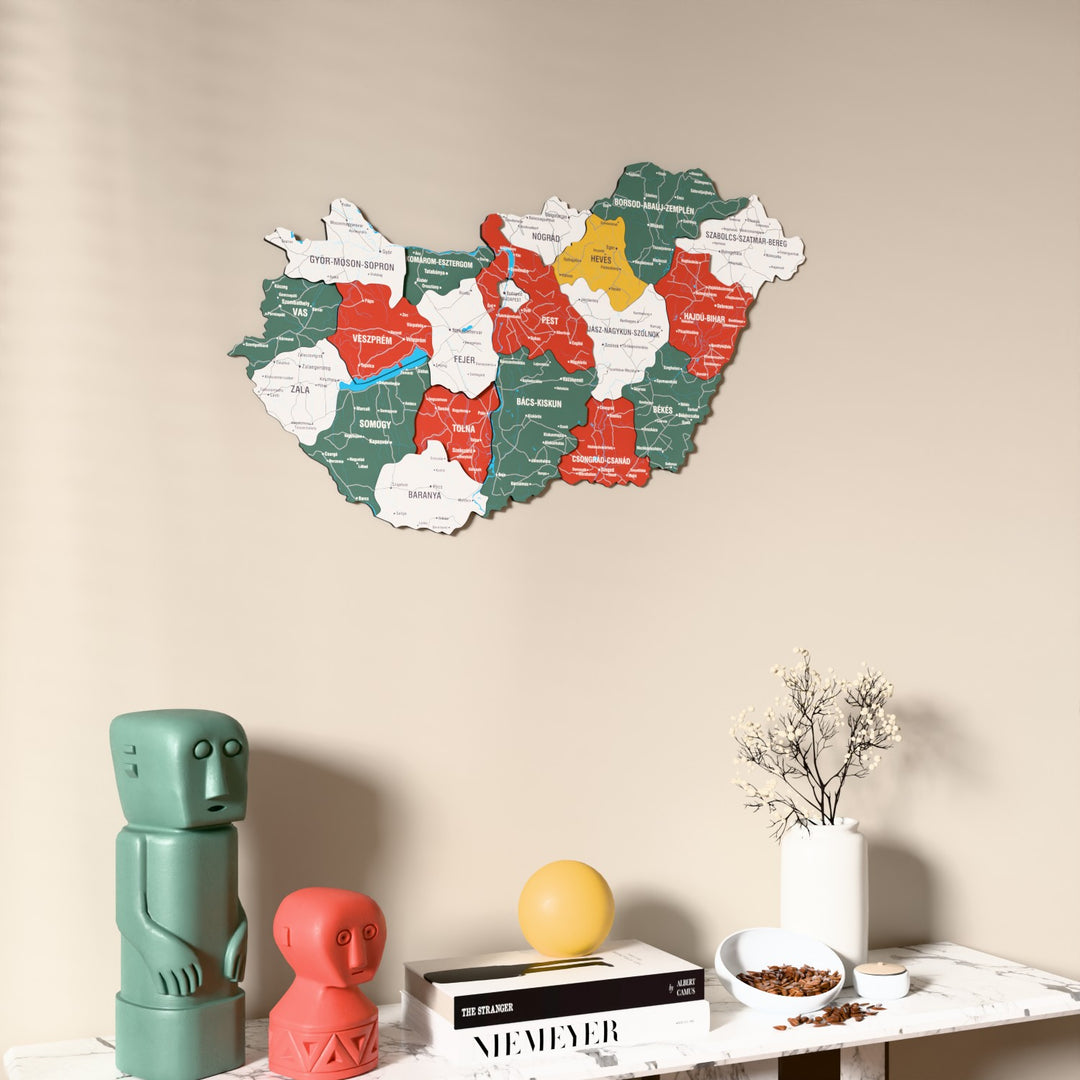 Flag colored Hungary wooden wall map on a beige wall above a console with figurines