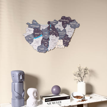 Nimbus Hungary wooden wall map on a beige wall above a console with figurines