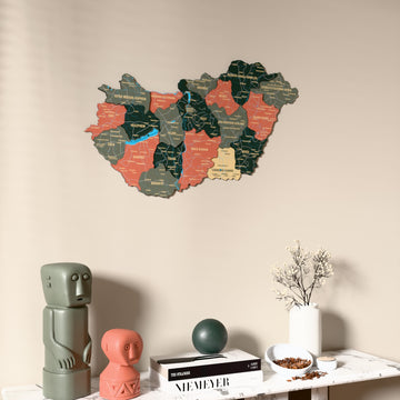 Sage Hungary wooden wall map on a beige wall above a console with figurines