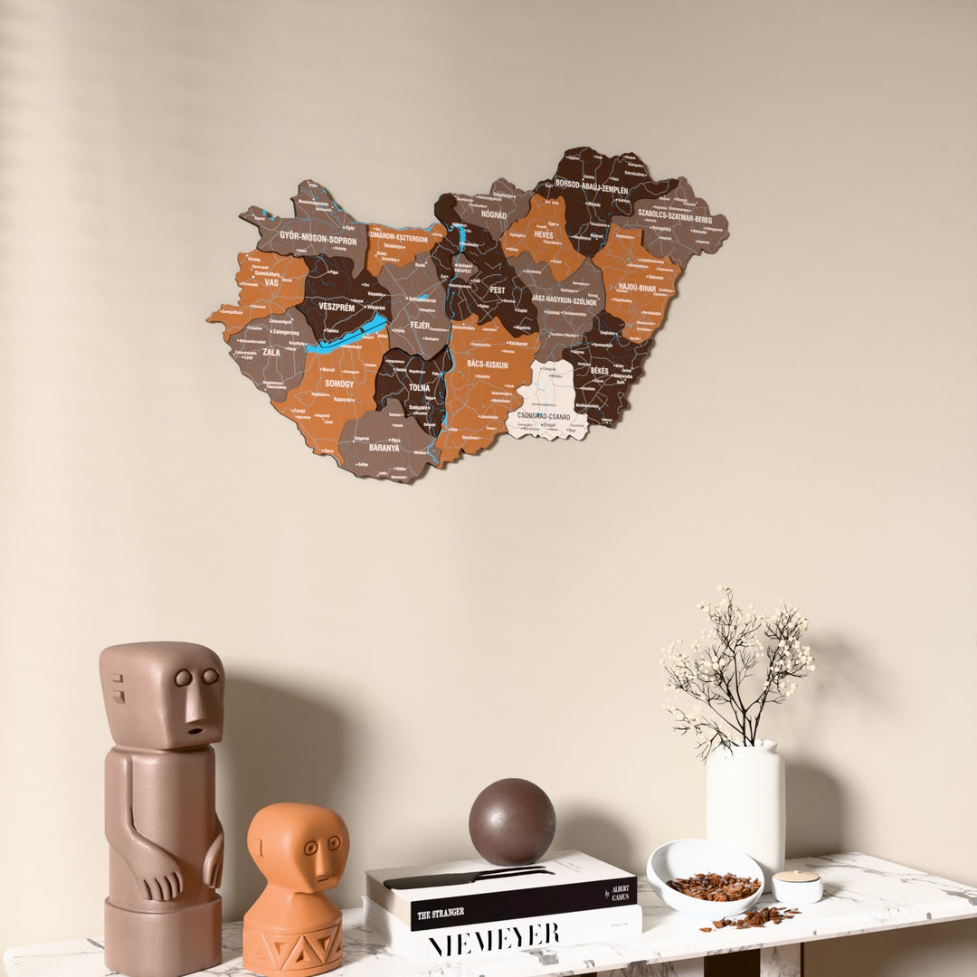Soil Hungary wooden wall map on a beige wall above a console with figurines
