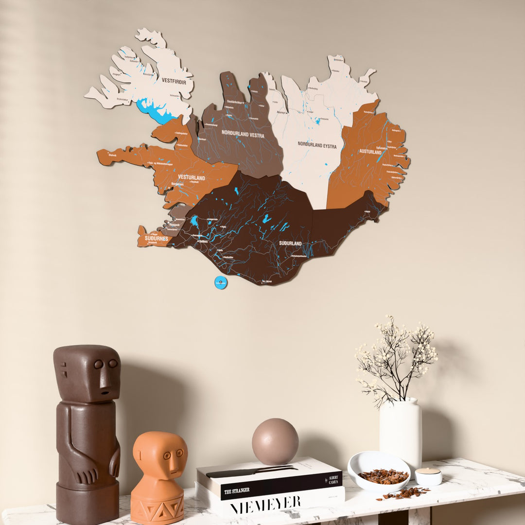 Soil Iceland wooden wall map on a beige wall above a console with figurines