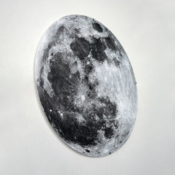 Metal Moon wall art in a steep angled view from the left, showing its thin edge and mounting studs