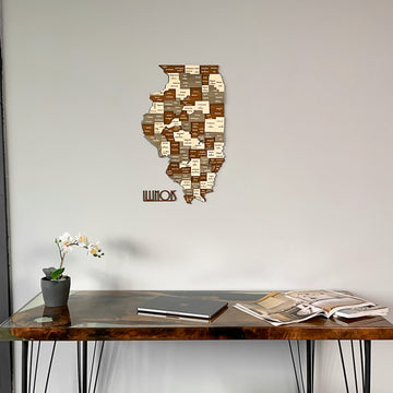 Wooden Illinois state map centered on the wall above a walnut desk with a laptop
