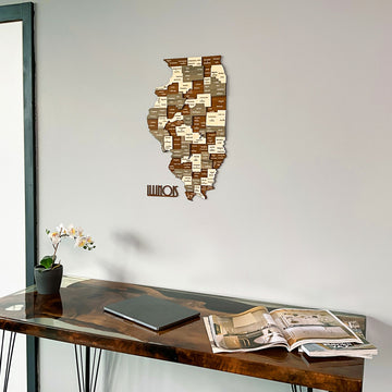 Wooden Illinois county map with state name piece, angled low view above a desk with a magazine