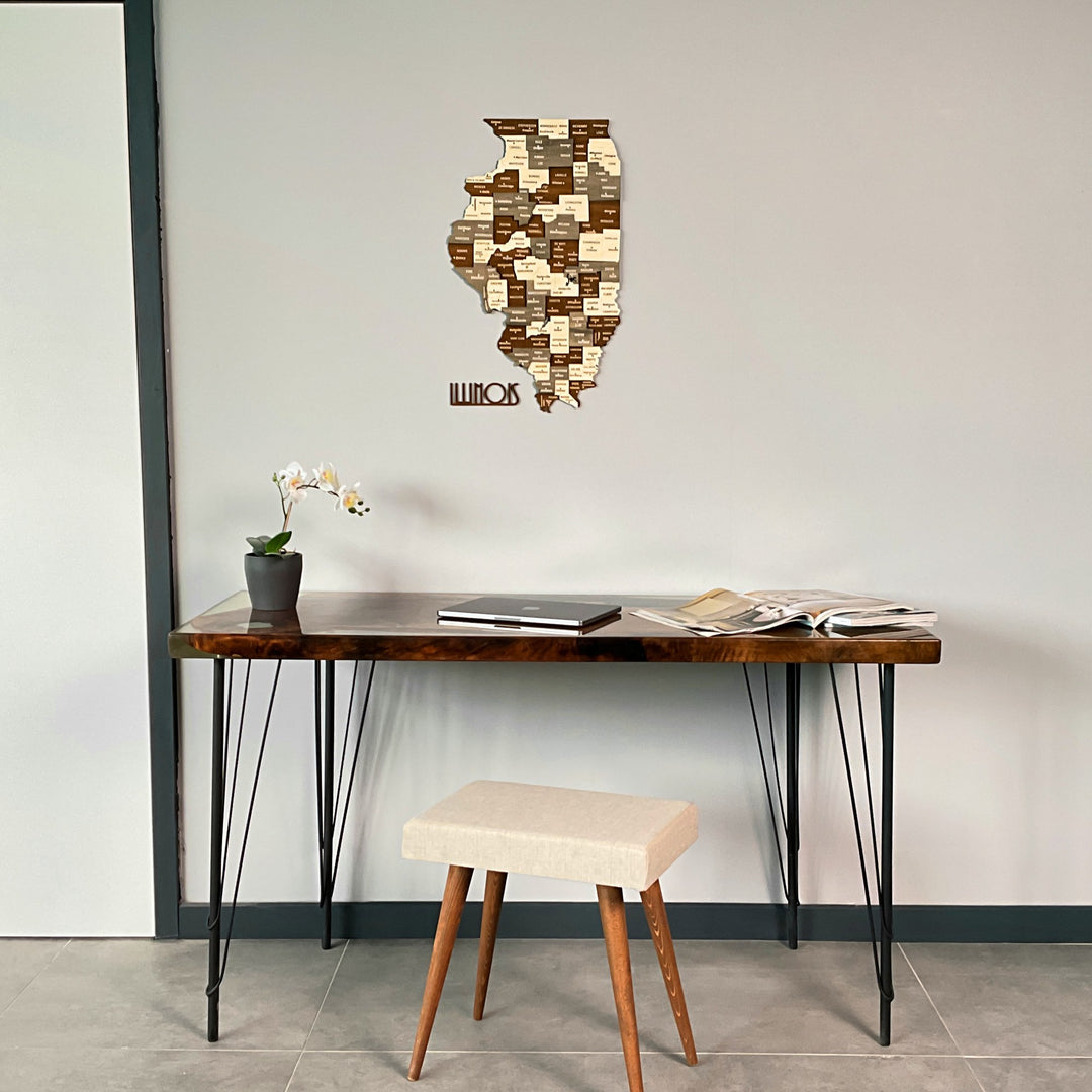 Multicolor wooden Illinois map hung high above a hairpin-leg desk and white stool, wide room view