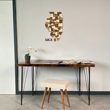 Multicolor wooden Illinois map hung high above a hairpin-leg desk and white stool, wide room view
