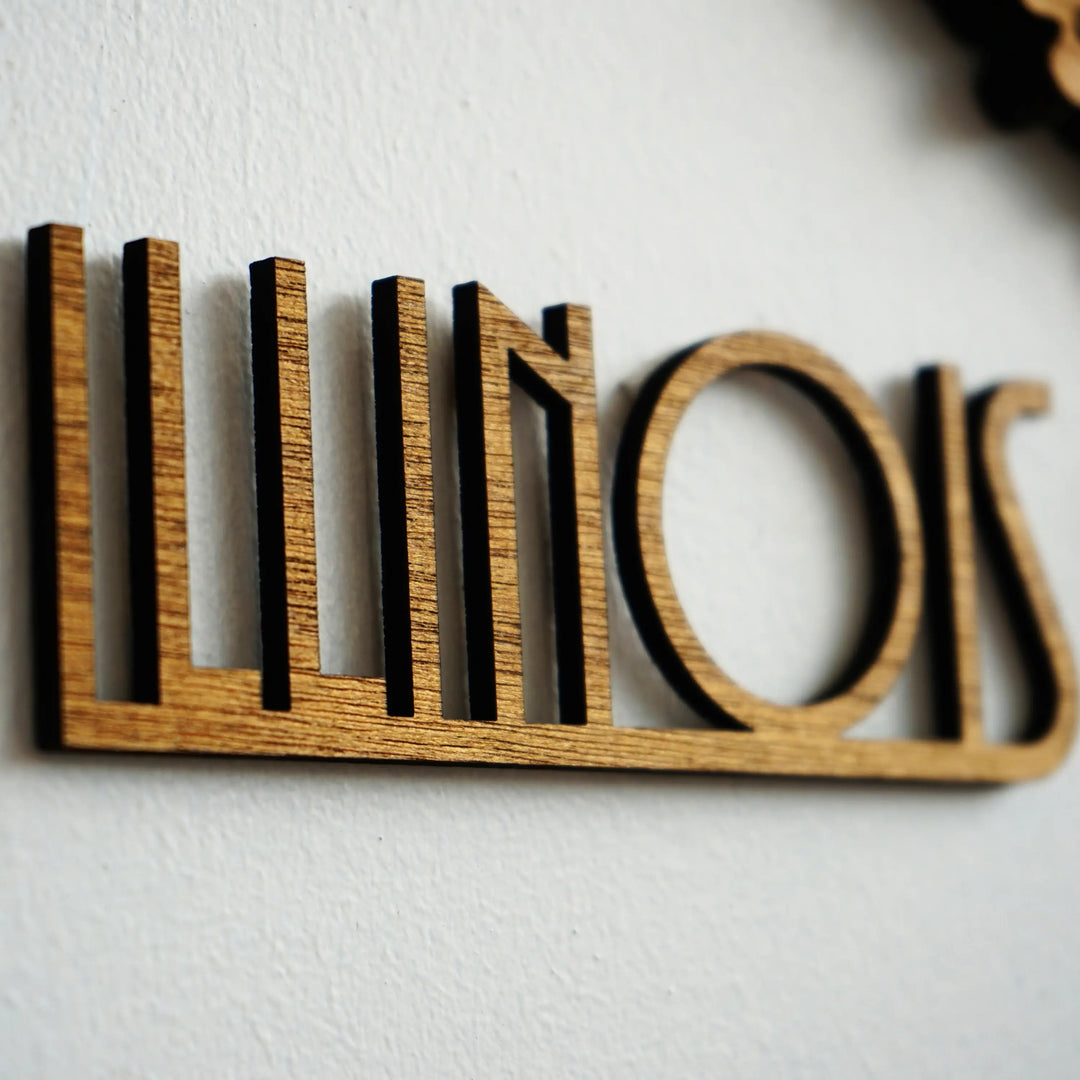 Close-up of the ILLINOIS name cut from wood in an art deco style lettering on a white wall