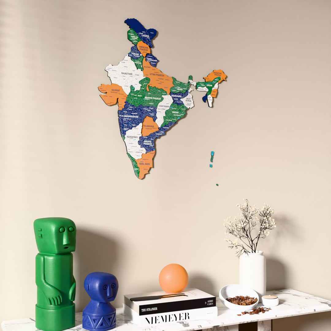Flag colored India wooden wall map on a beige wall above a console with figurines